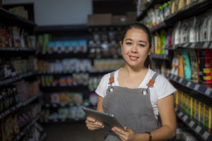 A worker smiles in a dark grocery store