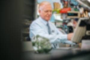 Blurred image of older man working as cashier