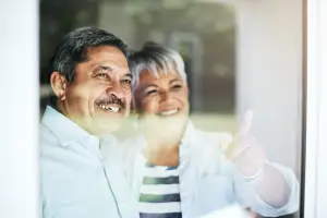 Couple looking out the window together, with the woman pointing