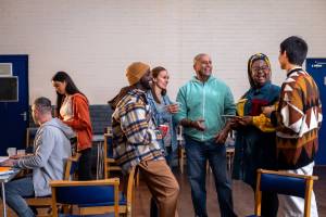 Group of people standing around talking at a community center