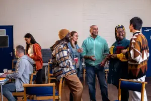 Group of people standing around talking at a community center