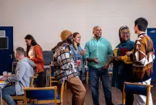 Group of people standing around talking at a community center