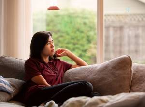 Teen sitting on the couch looking off to the side