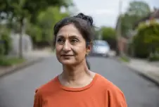 Woman standing in the street looking pensive