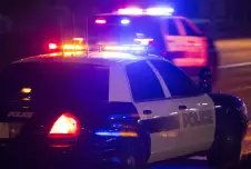 Two police cars with their lights on at night