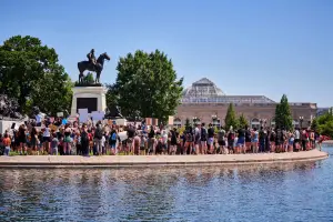 Group of protestors by a statue near water