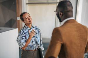 Coworker expressing gratitude to coworker with hand on her heart