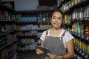 A worker smiles in a dark grocery store