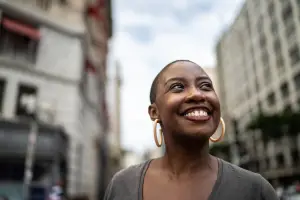 Woman in the street looking up and smiling