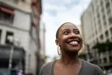 Woman in the street looking up and smiling