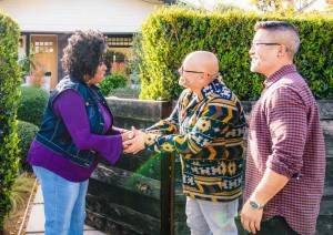 Three neighbors meeting outdoors and shaking hands