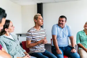 People seated in a circle for group therapy