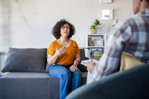 Client sitting on couch talking to therapist