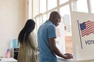Two people voting in a voting booth