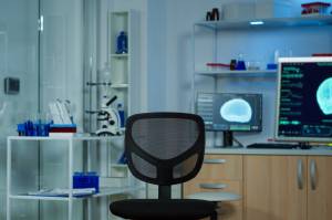 Empty chair in a neurology lab with equipment behind it