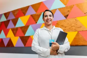 Worker with a clipboard standing in front of a patterned wall
