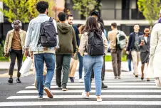 Lots of people passing by each other on a crosswalk