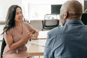 Two workers sitting at a table having a conversation