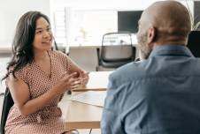 Two workers sitting at a table having a conversation