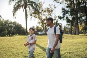Father and son walking in the park talking