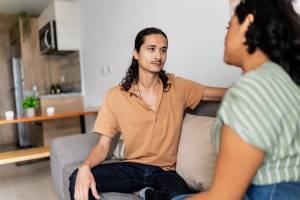 Couple sitting on the couch having a serious conversation