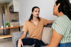 Couple sitting on the couch having a serious conversation