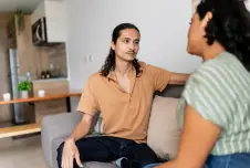 Couple sitting on the couch having a serious conversation
