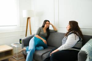 Two women chatting on a couch