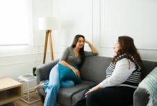 Two women chatting on a couch 