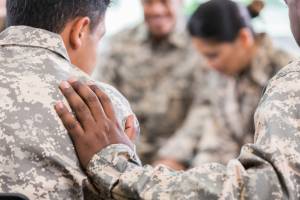 Group of soldiers sitting in a circle, supporting each other
