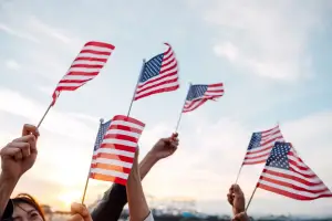 People waving American flags above their heads