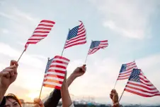People waving American flags above their heads