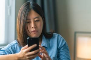 Woman with a serious expression looking at her smartphone
