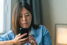 Woman with a serious expression looking at her smartphone