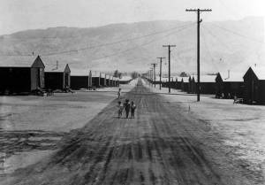 Children walking down a road with buildings on each side 
