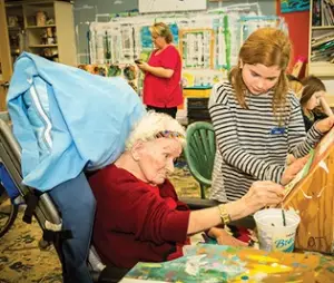 A student and an elder doing an art activity