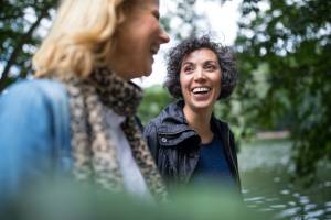 Two women walking, talking, and smiling