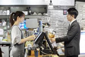 Barista ringing up a customer in a suit
