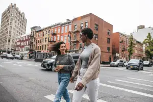 Two women crossing a crosswalk in the city