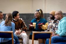 Group of people sitting in a circle having a serious conversation
