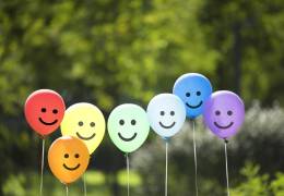 Seven balloons with smiley faces on them
