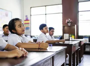 Students at their desks looking up at the teacher