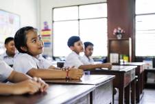Students at their desks looking up at the teacher