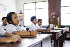 Students at their desks looking up at the teacher