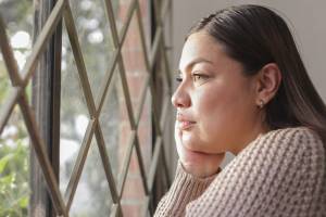 Woman looking out a grated window