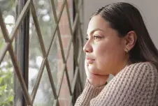 Woman looking out a grated window