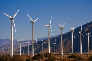 Line of wind turbines with mountains in the background
