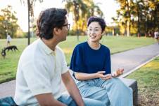 Two people talking on a park bench