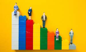 Figurines standing on colorful blocks stacked at different heights