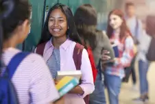 Middle school girls standing in front of lockers talking
